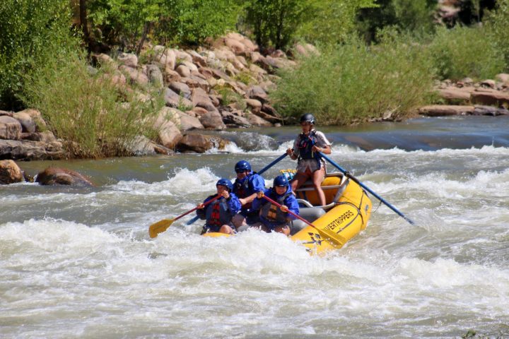 a group of people riding on a raft in a body of water