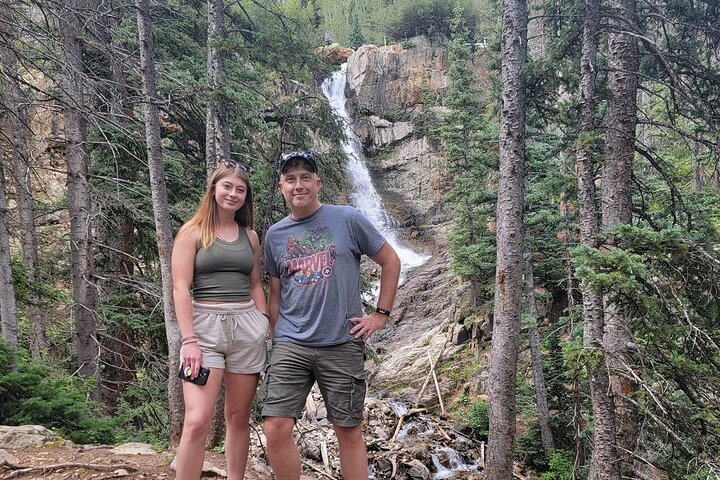 a person standing next to a forest